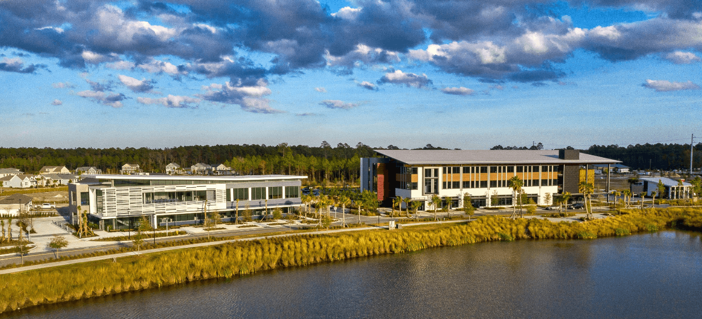 The Rayonier headquarters building and another commercial building next to a pond in Wildlight.